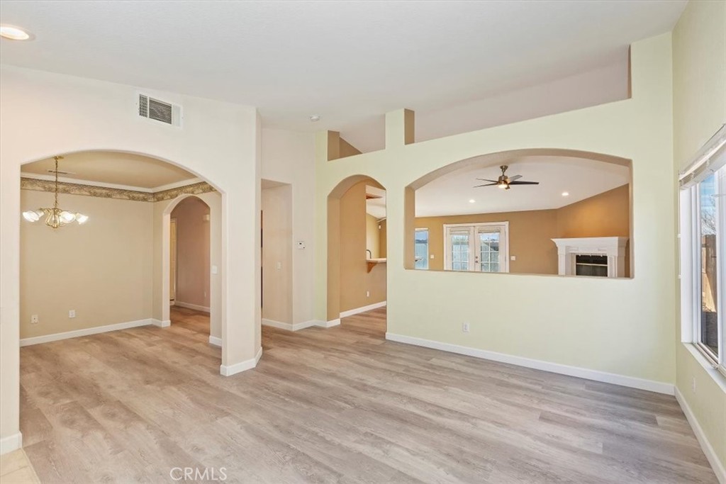 12278 Shadow Drive Victorville, CA 92392 - Photo 5 of 32 a view of an empty room with wooden floor and a window