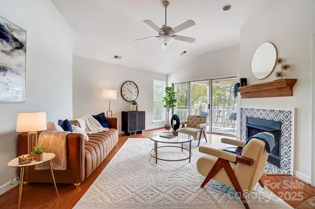 a living room with furniture a fireplace and a floor to ceiling window
