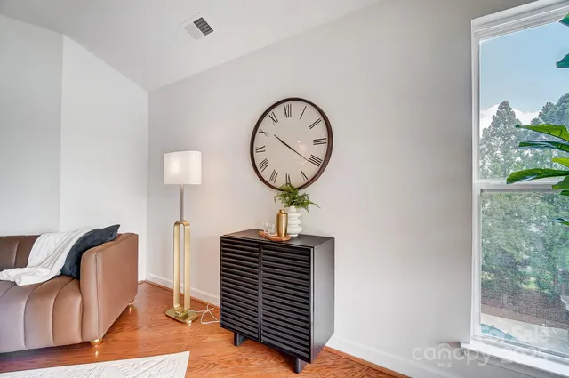 a view of a livingroom with wooden floor a fireplace and a window