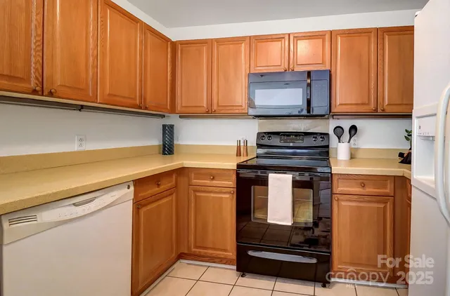 a kitchen with stainless steel appliances granite countertop white cabinets sink and window