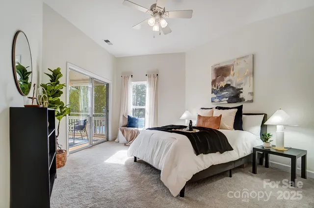 a bedroom with a bed a mirror on dresser and a chandelier