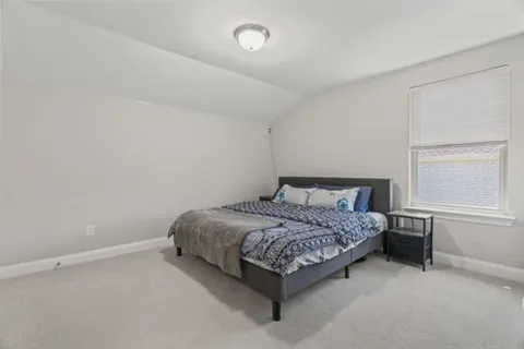 a bed sitting in a bedroom next to a bathroom