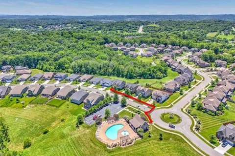 a view of a swimming pool with lawn chairs under an umbrella