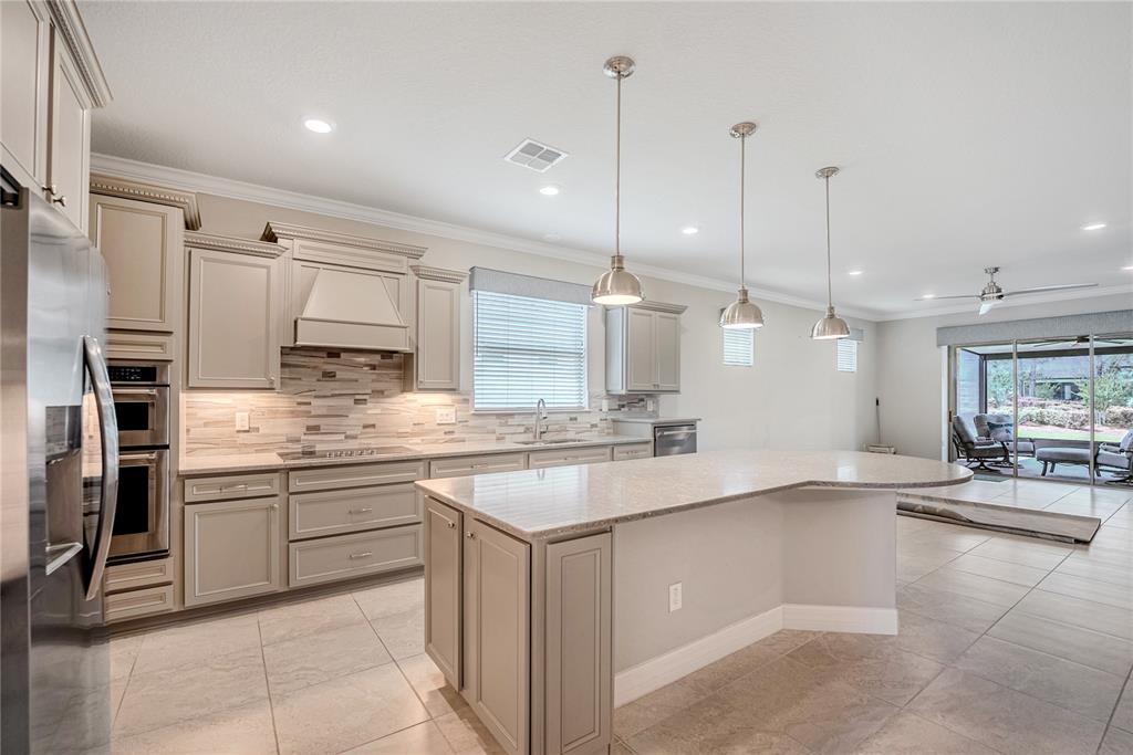 9550 Southwest 64th Lane Ocala, FL 34481 - Photo 18 of 58 a large kitchen with kitchen island a sink stainless steel appliances and cabinets