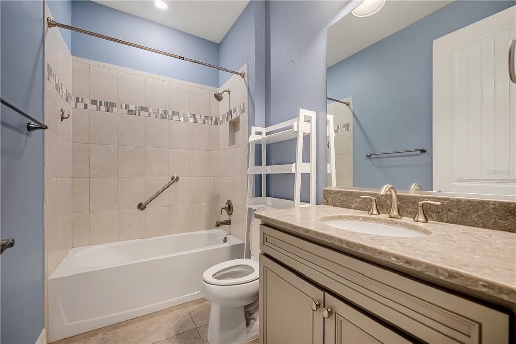 9550 Southwest 64th Lane Ocala, FL 34481 - Photo 30 of 58 a bathroom with a granite countertop bathtub sink vanity mirror and toilet