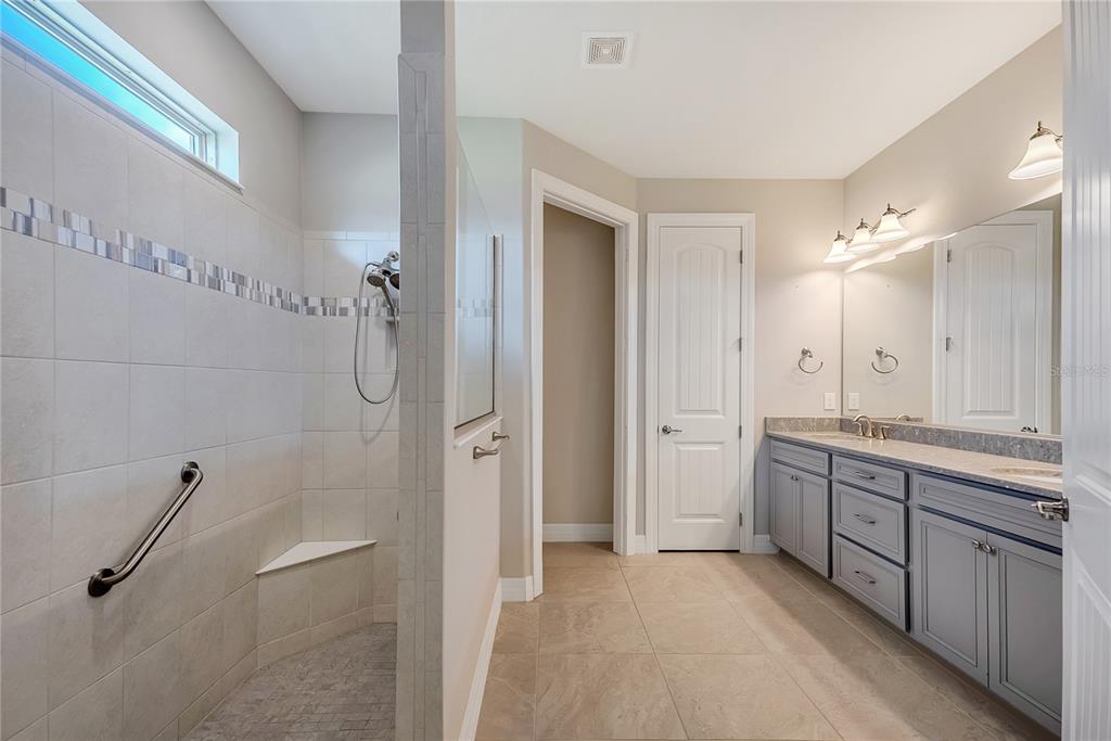 9550 Southwest 64th Lane Ocala, FL 34481 - Photo 37 of 58 a spacious bathroom with a granite countertop sink mirror and a bathtub