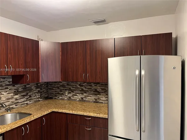 a kitchen with a refrigerator a sink and cabinets