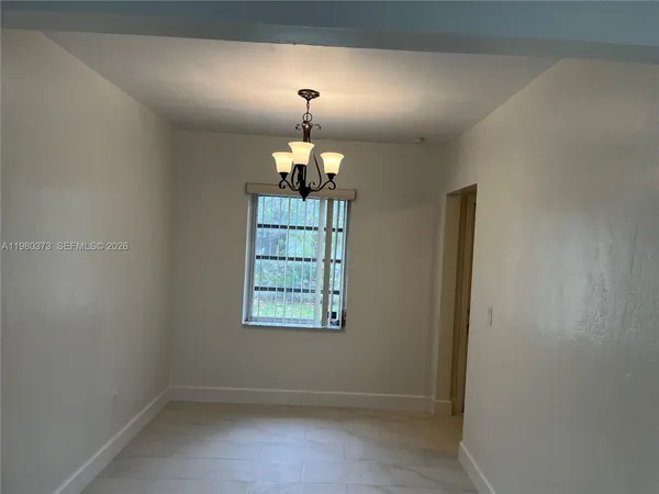 an empty room with windows and chandelier