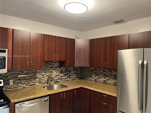 a kitchen with wooden cabinets and a refrigerator