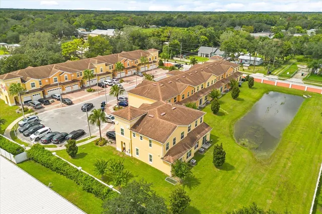 an aerial view of residential houses with outdoor space and trees