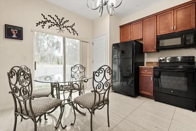 a kitchen with stainless steel appliances granite countertop a stove a refrigerator with a dining table and chairs