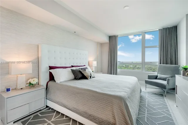 a bedroom with a bed and a large window