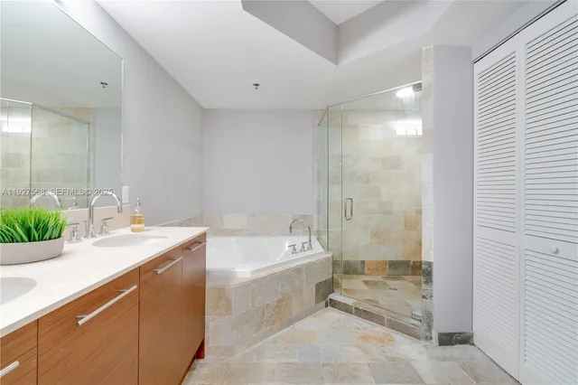 a spacious bathroom with a tub sink and mirror