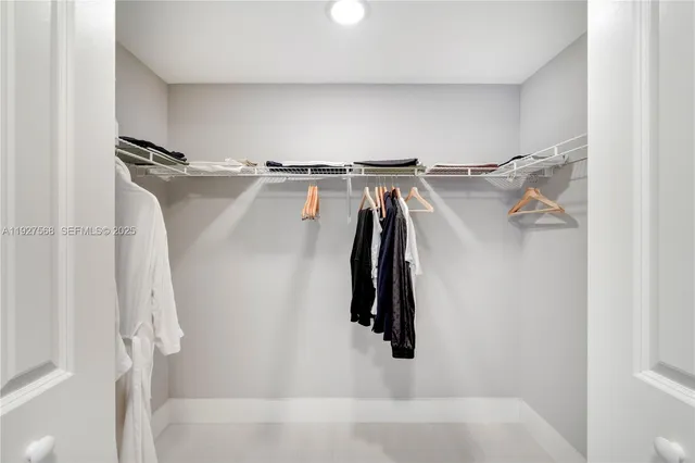 a view of walk in closet with clothes