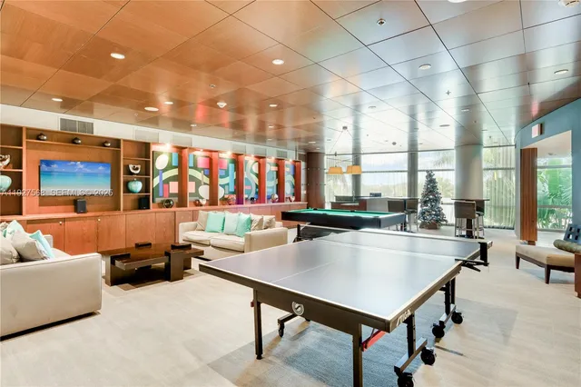 a living room with furniture a table and a floor to ceiling window
