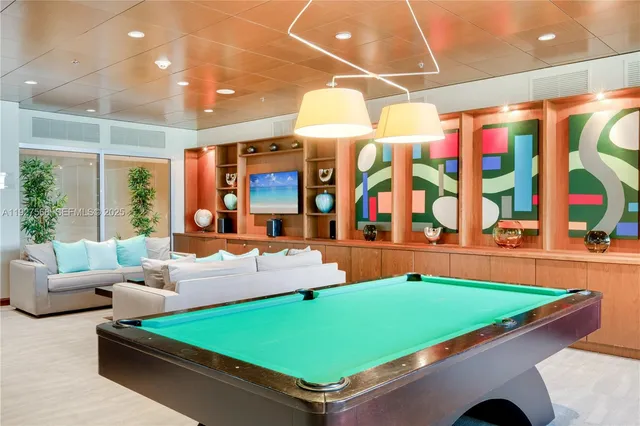 a room with pool table and windows