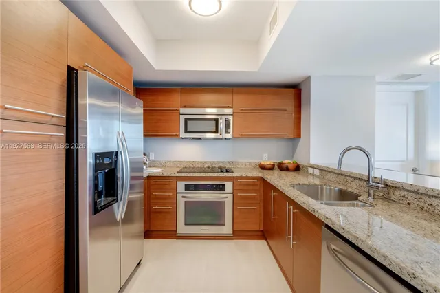 a kitchen with stainless steel appliances granite countertop a sink stove and refrigerator