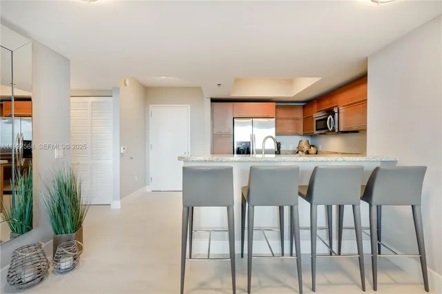 a kitchen with stainless steel appliances granite countertop a dining table chairs and granite counter tops