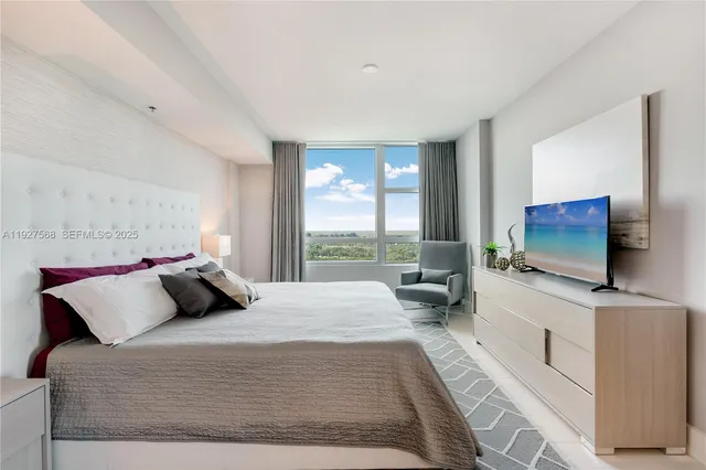 a bedroom with a bed and a flat screen tv