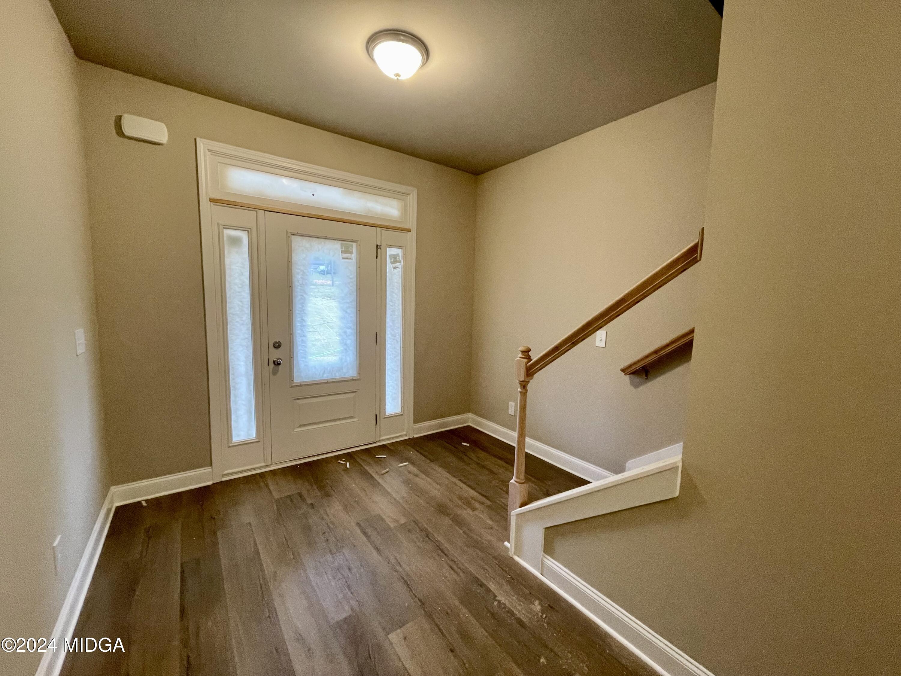 149 Strickland Loop Forsyth, GA 31029 - Photo 3 of 12 a view of an empty room with wooden floor and a window