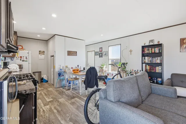 a living room with furniture a bookshelf and a window