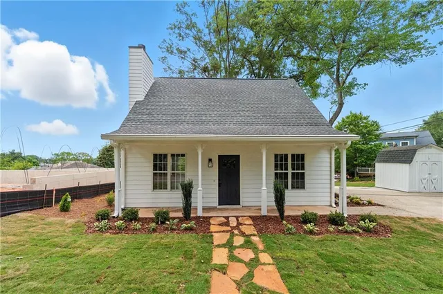 a backyard of a house with yard table and chairs