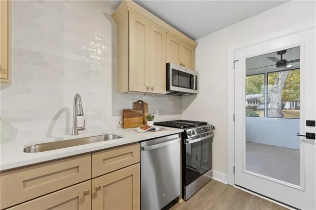 a kitchen with stainless steel appliances granite countertop a sink stove and refrigerator