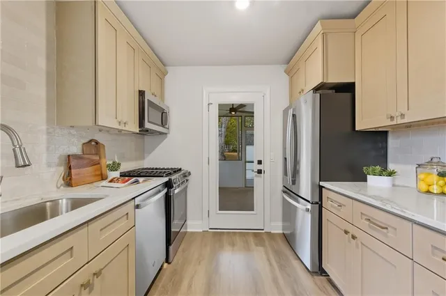 a kitchen with a sink cabinets stainless steel appliances and a window