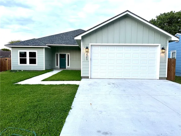 a view of house with yard and garage