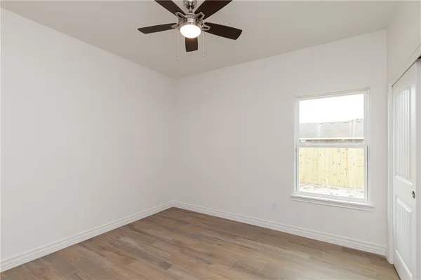 an empty room with a window and a fan