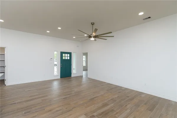 a view of an empty room with wooden floor