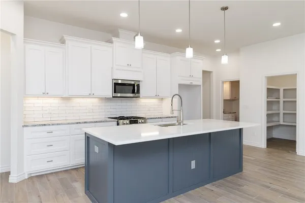 a kitchen with a sink a stove and cabinets