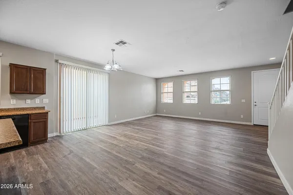 a view of an empty room with a kitchen and a window