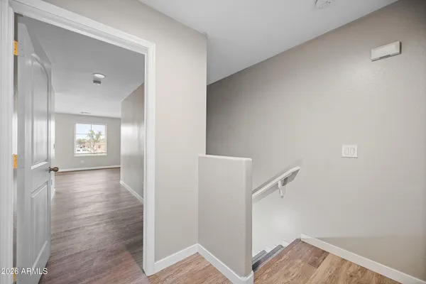 a view of a hallway with wooden floor and closet area