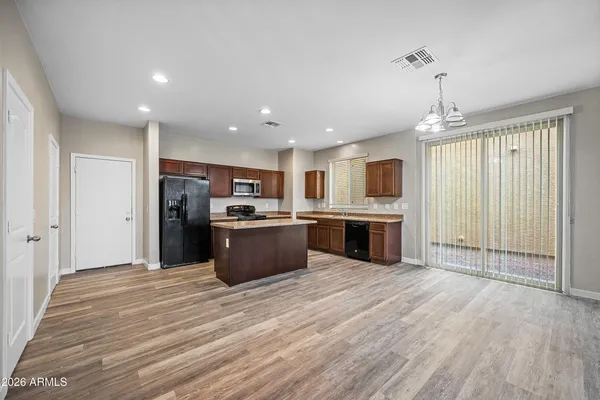 a large kitchen with stainless steel appliances granite countertop a stove refrigerator and a microwave oven