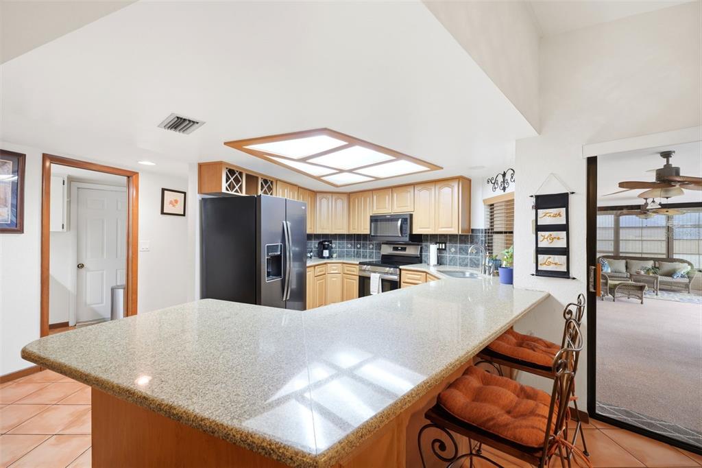 5227 Suwannee Road Weeki Wachee, FL 34607 - Photo 16 of 62 a large white kitchen with a large window and stainless steel appliances