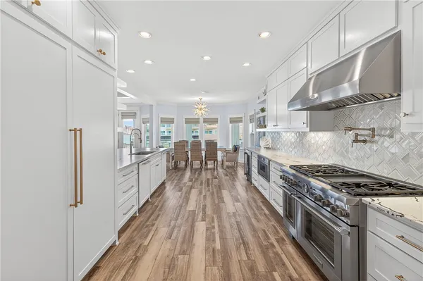 a kitchen with counter top space a sink wooden floor and stainless steel appliances