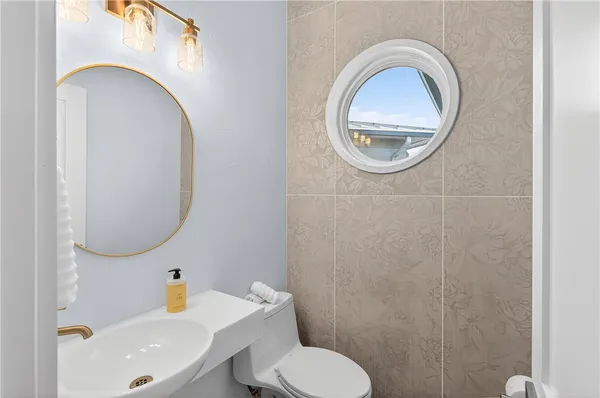 a bathroom with a toilet a sink and a mirror