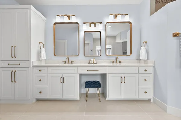 a bathroom with double vanity white cabinets and a mirror