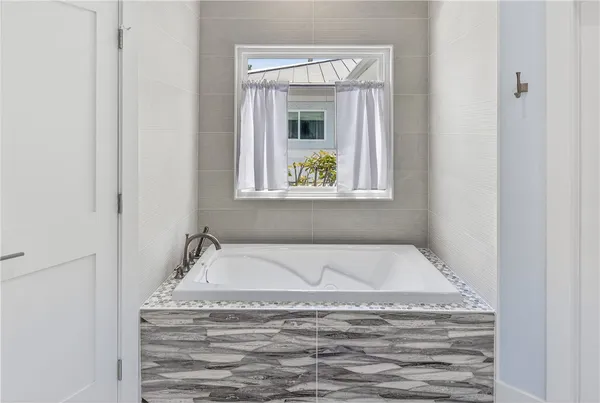 a bathroom with tub and window