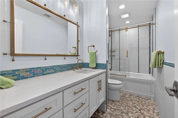 a bathroom with a sink a toilet and a mirror