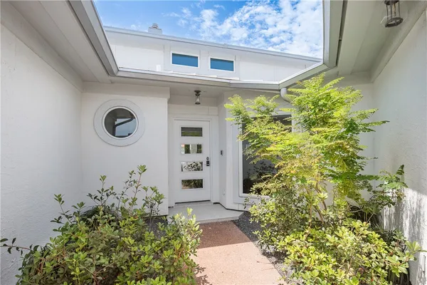 a front view of a house with plants