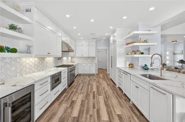 a view of a kitchen with kitchen island a sink stainless steel appliances and cabinets