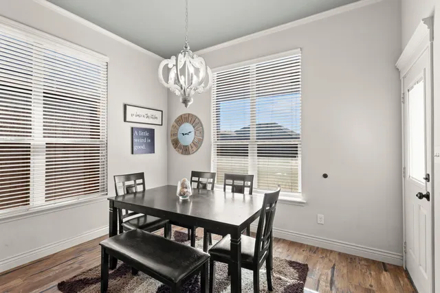a view of a dining room with furniture a chandelier and wooden floor