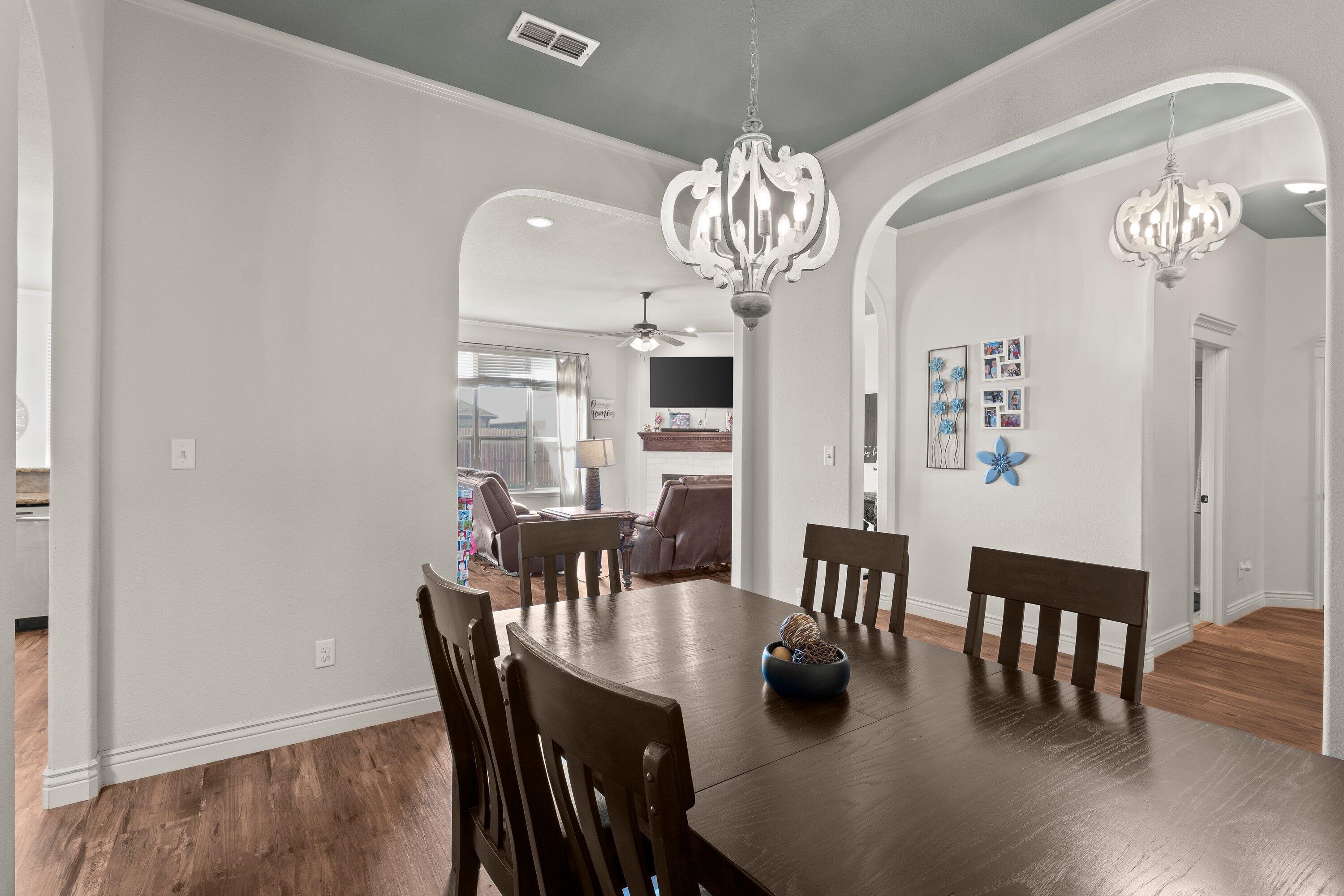 6305 93rd Street Lubbock, TX 79424 - Photo 13 of 31 a view of a dining room with furniture wooden floor and chandelier