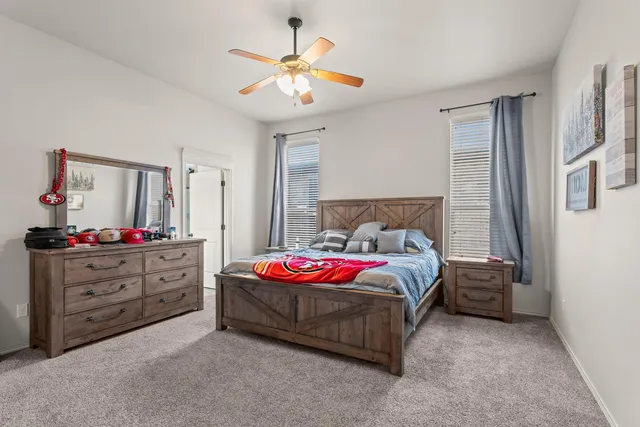a spacious bedroom with a bed and a chandelier