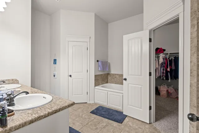 a en suite bathroom with a granite countertop tub and a sink