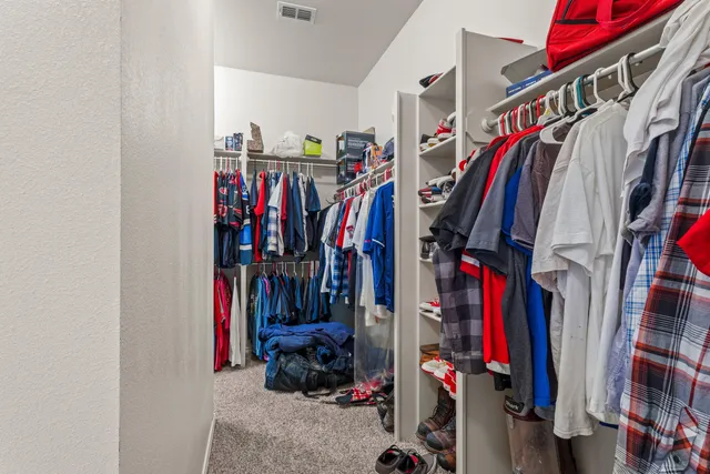 a view of walk in closet with clothes and shoes