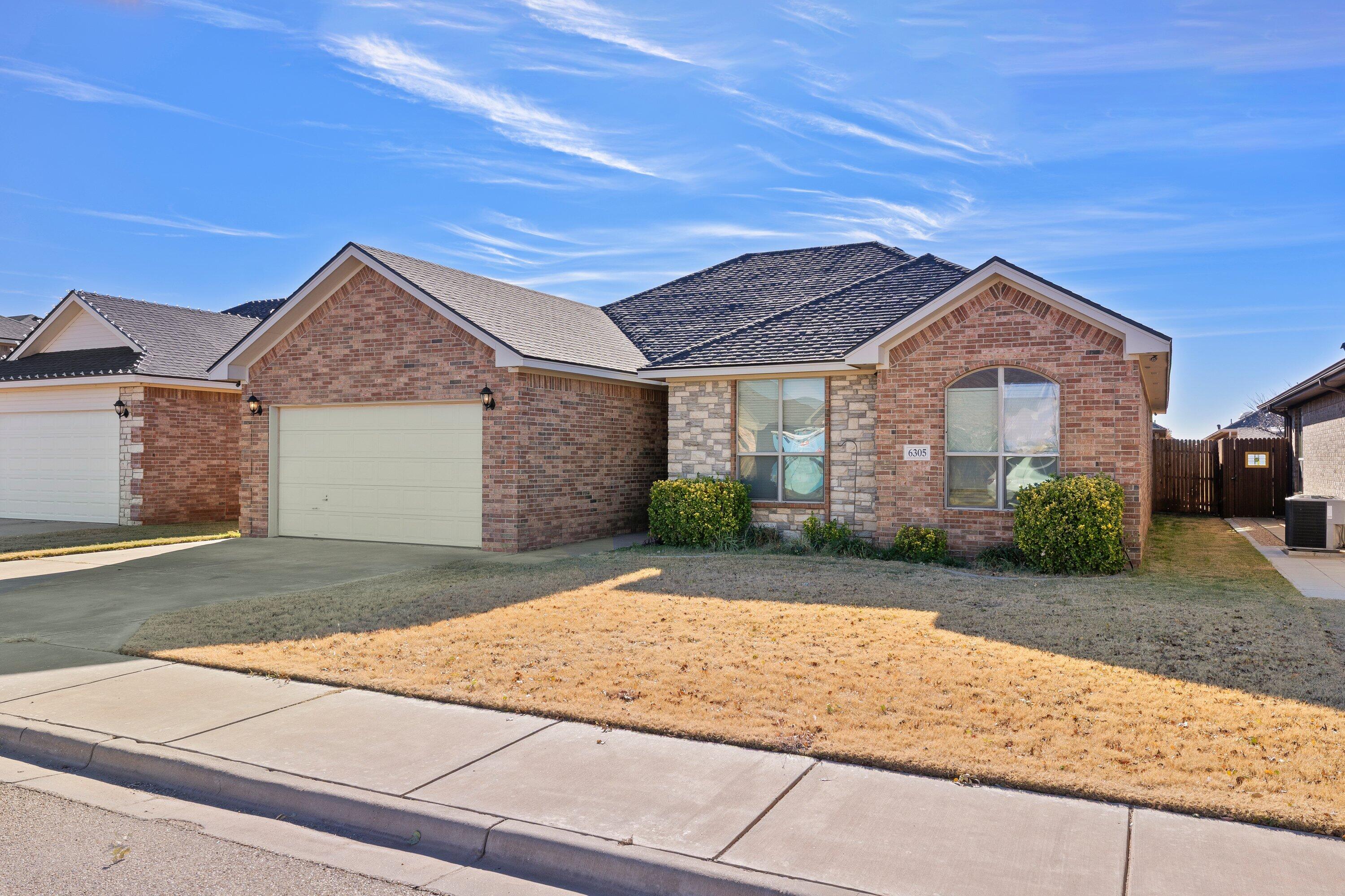 6305 93rd Street Lubbock, TX 79424 - Photo 2 of 31 a front view of a house with a yard