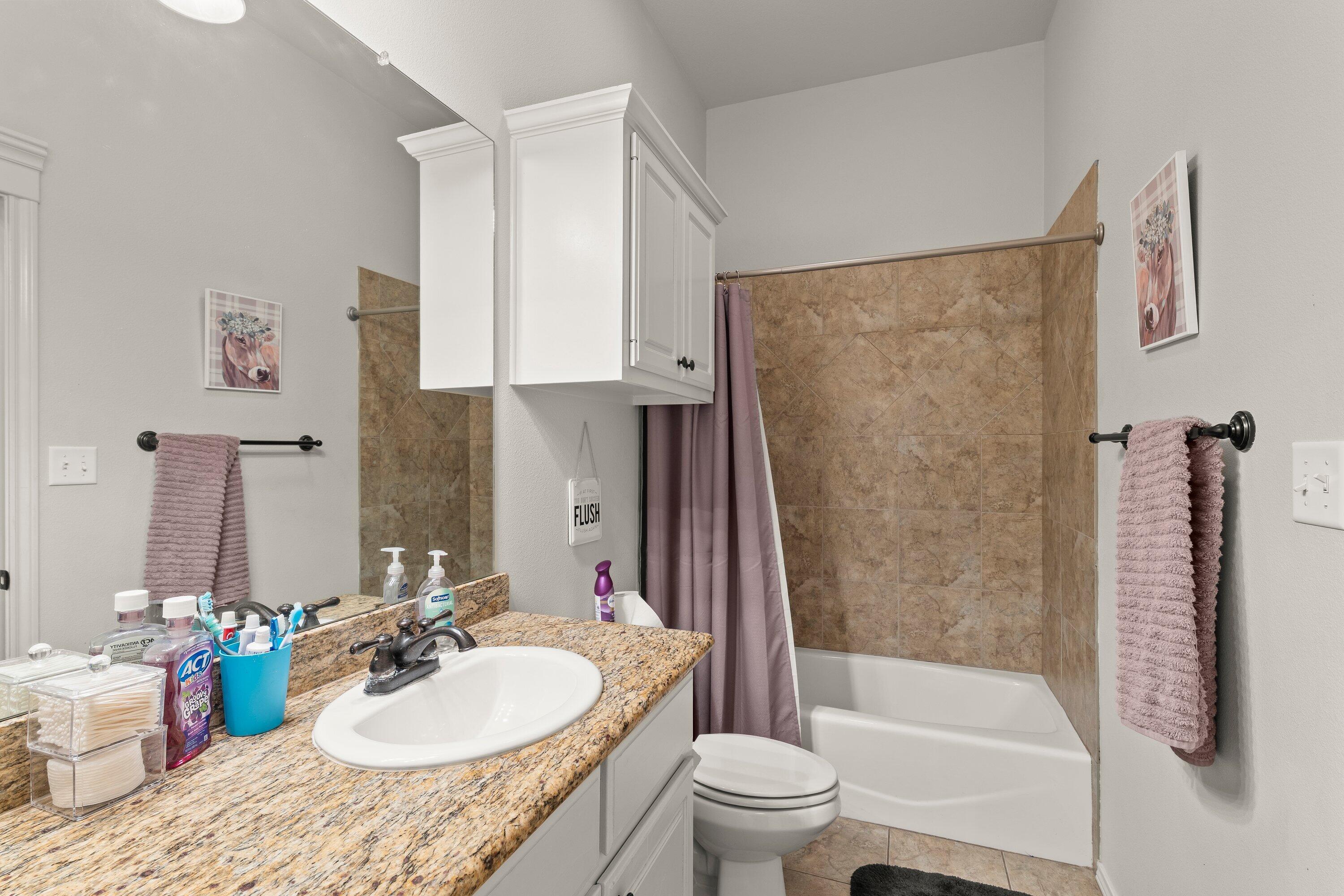 6305 93rd Street Lubbock, TX 79424 - Photo 22 of 31 a bathroom with a granite countertop sink toilet and shower